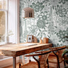 Wallpaper 1458: Large-scale sage green botanical illustration wallpaper with wildflowers and stems on a white background, styled behind a wood desk with natural lighting and woven chairs.