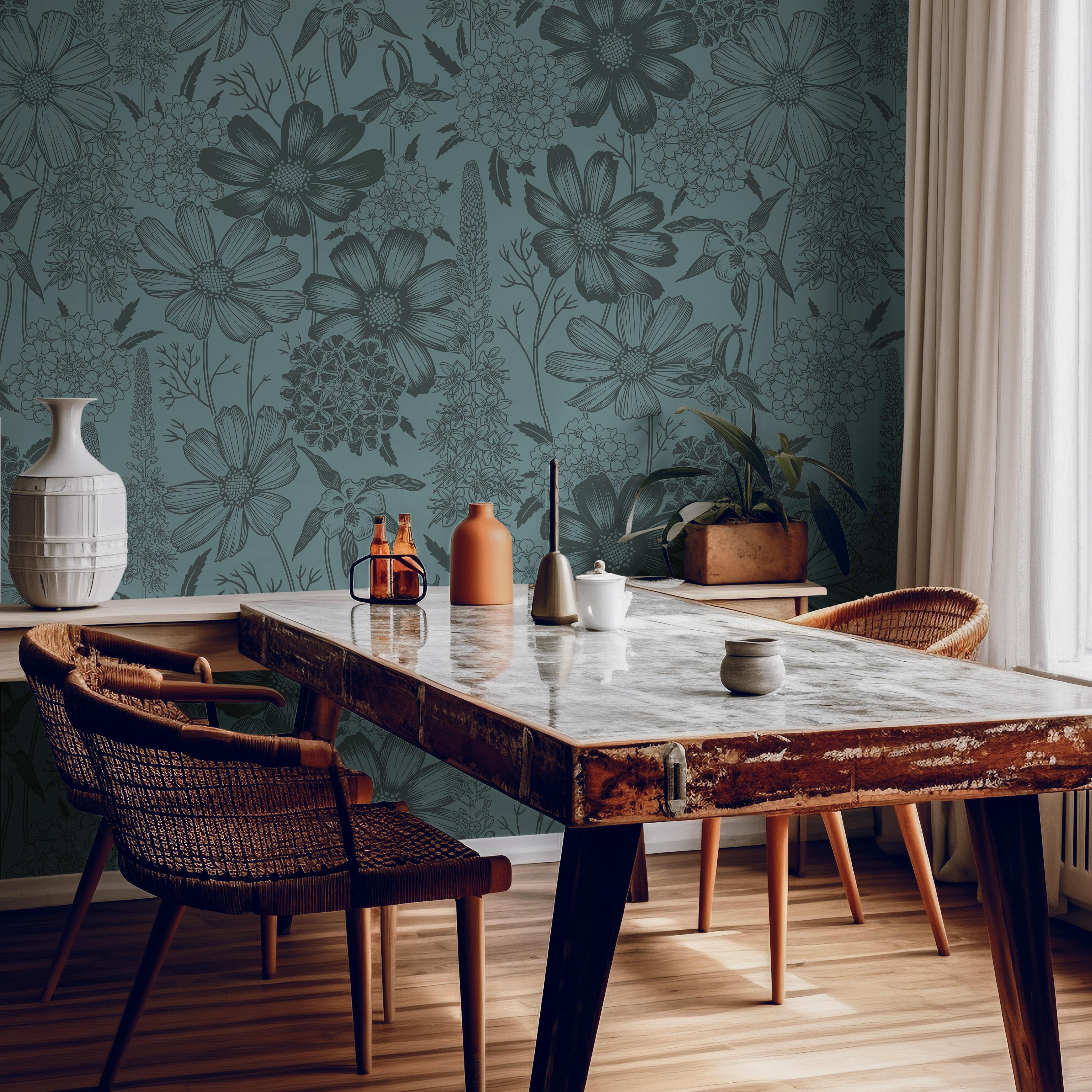 Wallpaper 1482: Deep green wallpaper with hand-drawn botanical illustrations in a darker tone, featuring wildflowers and foliage, styled behind a rustic wooden dining table with woven chairs and natural decor.