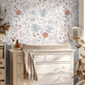 Wallpaper 1655: Soft floral wallpaper with hand-drawn blue, rust, and gray flowers in a nursery behind a white changing table and dresser, styled with warm neutral tones and natural light.