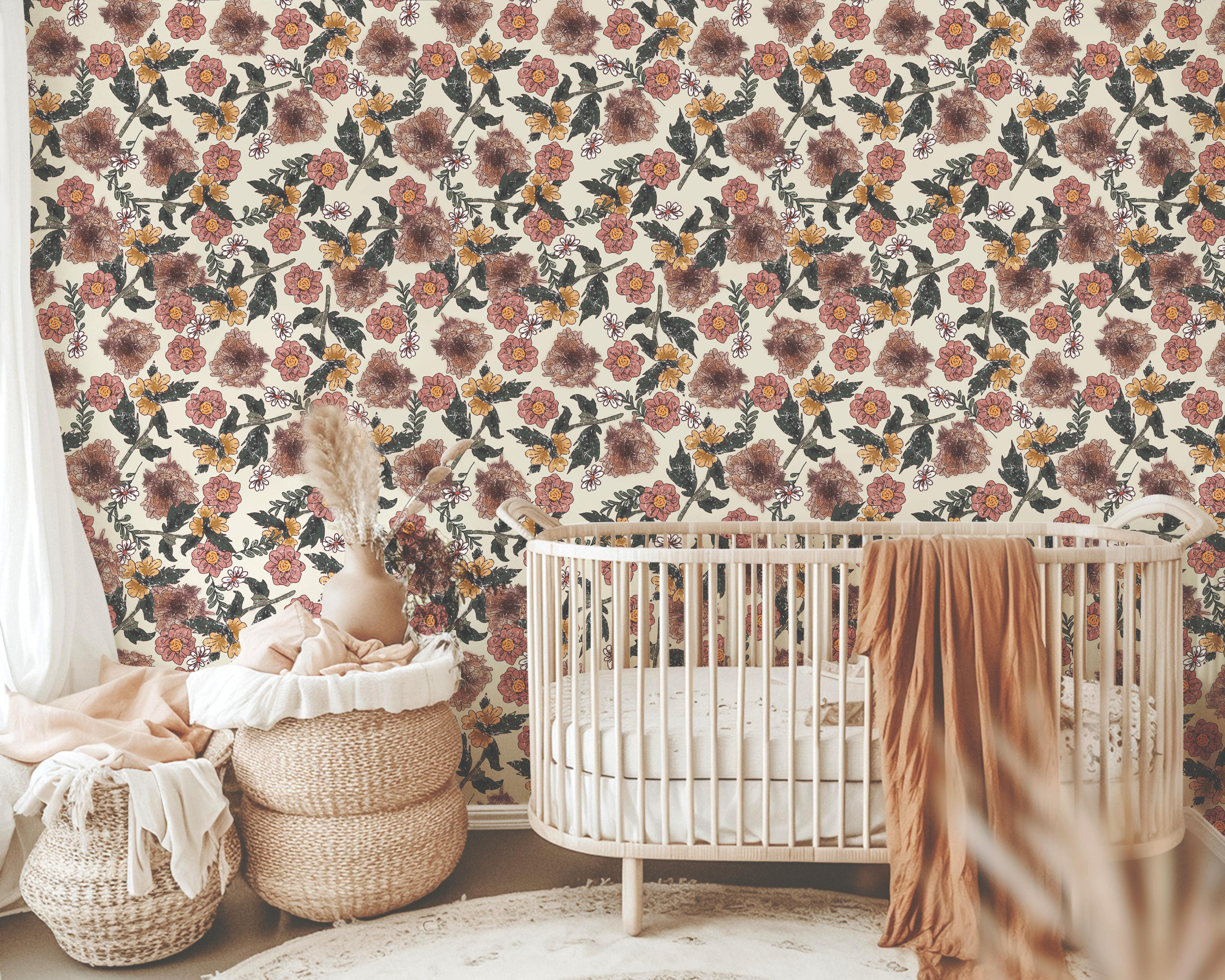 Wallpaper 1940: Wallpaper with plum purple, burnt orange, and mustard yellow floral motifs layered with green leaves on a light beige background, styled in a nursery with a natural wood crib and woven baskets.