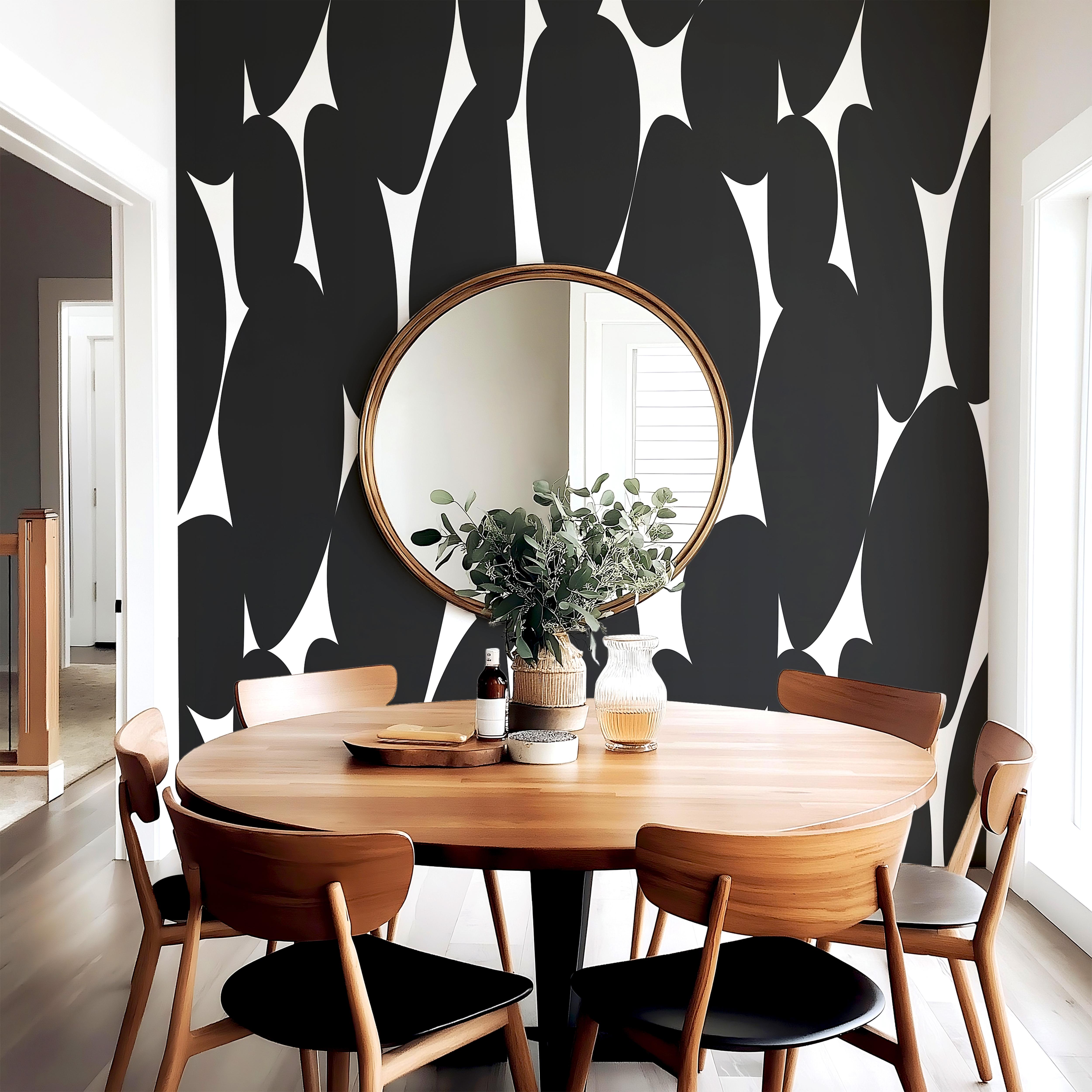 Wallpaper 1957: Modern dining room with round wood table and minimalist chairs set against a bold black-and-white abstract wallpaper featuring large curved organic shapes.