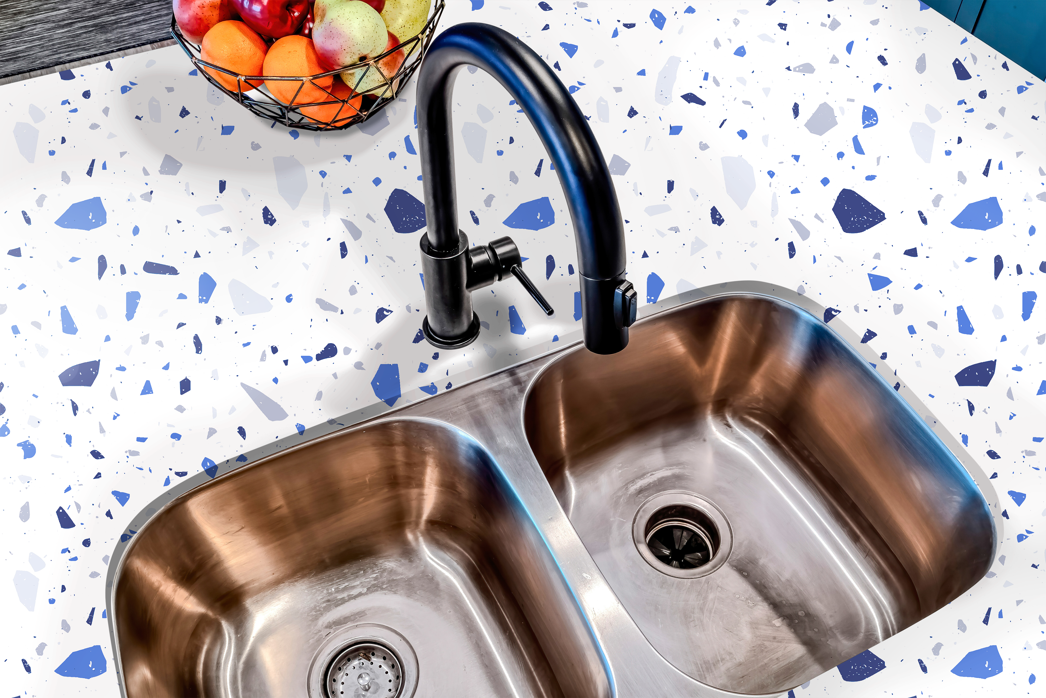 A modern kitchen featuring a sleek white countertop with a blue terrazzo-patterned adhesive film, enhancing the space with a stylish and contemporary speckled design.