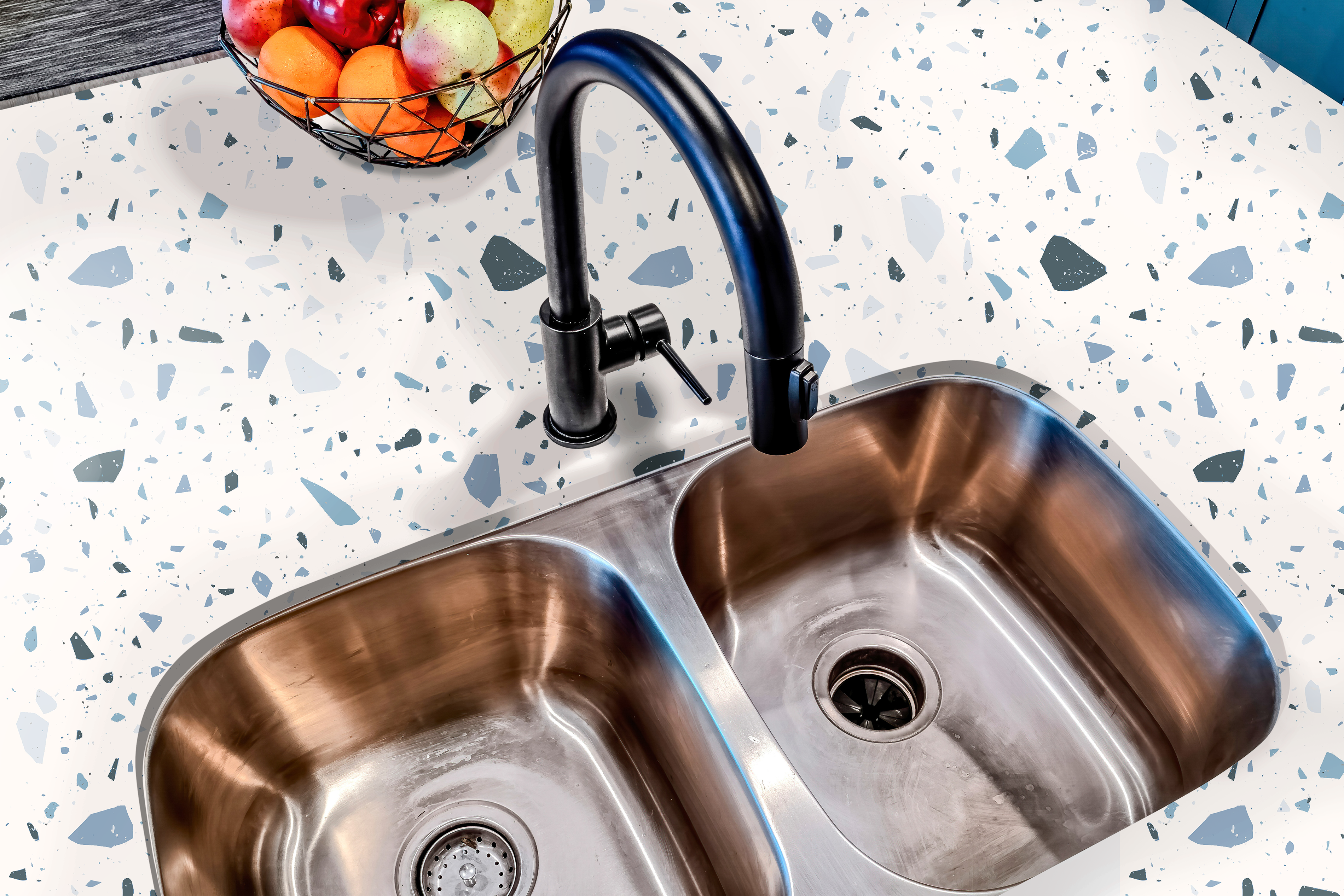 Countertop film 51: A stylish kitchen countertop covered in a white and blue terrazzo-patterned adhesive film, featuring a modern design with scattered stone-like flecks for a contemporary look.
