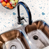 Countertop film 52: A modern kitchen countertop covered in blue terrazzo contact paper, featuring a speckled pattern of blue and white stone-like fragments. 