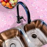 Countertop film 55: A close-up of a pink terrazzo countertop film applied to a kitchen counter with a stainless steel sink. The speckled adhesive film features white, pink, and blue flecks, creating a modern terrazzo pattern for stylish kitchen decor.