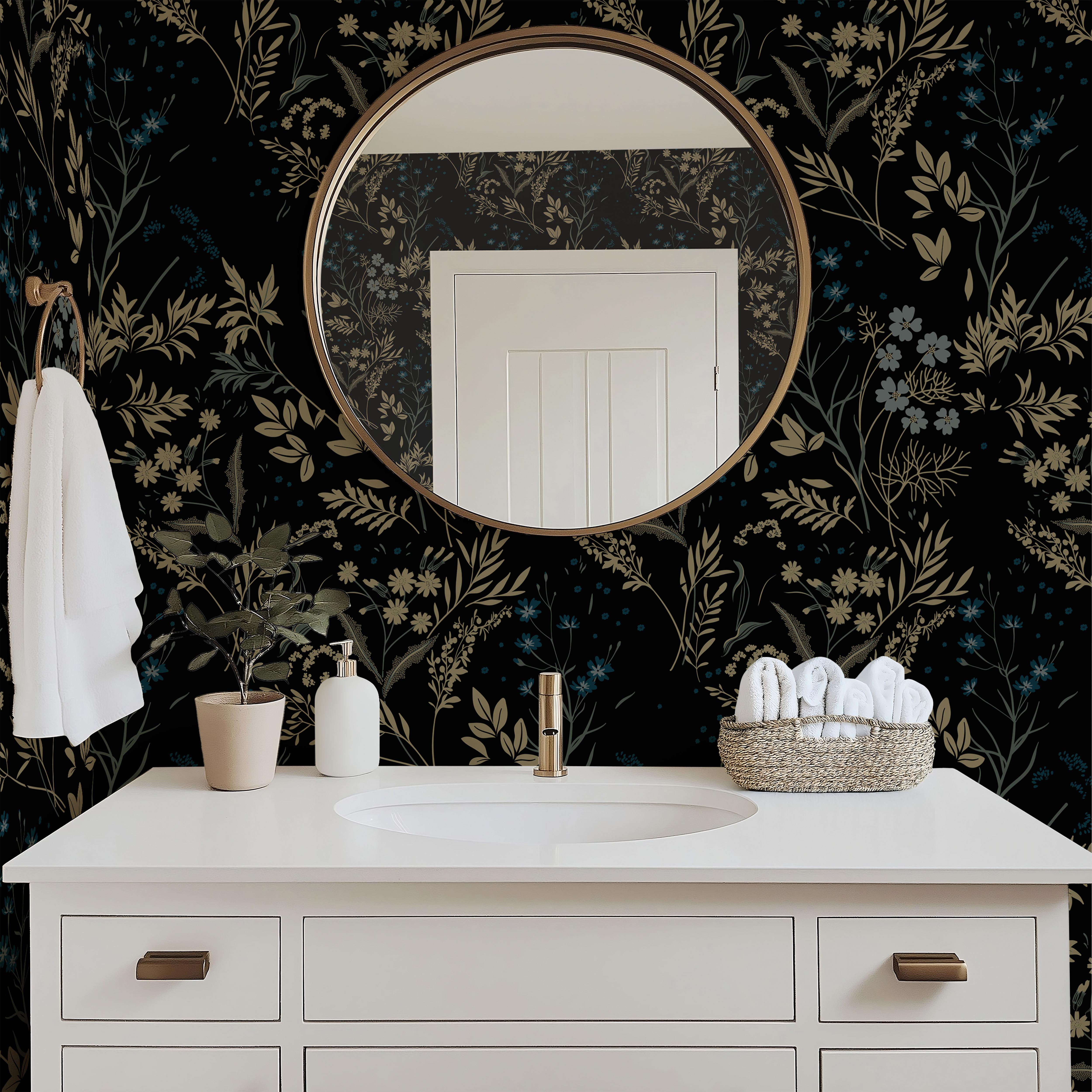 Blackmoor black floral wallpaper in a modern bathroom with a white vanity, brass mirror, and botanical décor.