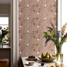 Barleymont wallpaper featuring earthy taupe and wheat-beige tones in a softly textured pattern installed in a modern kitchen/dining interior