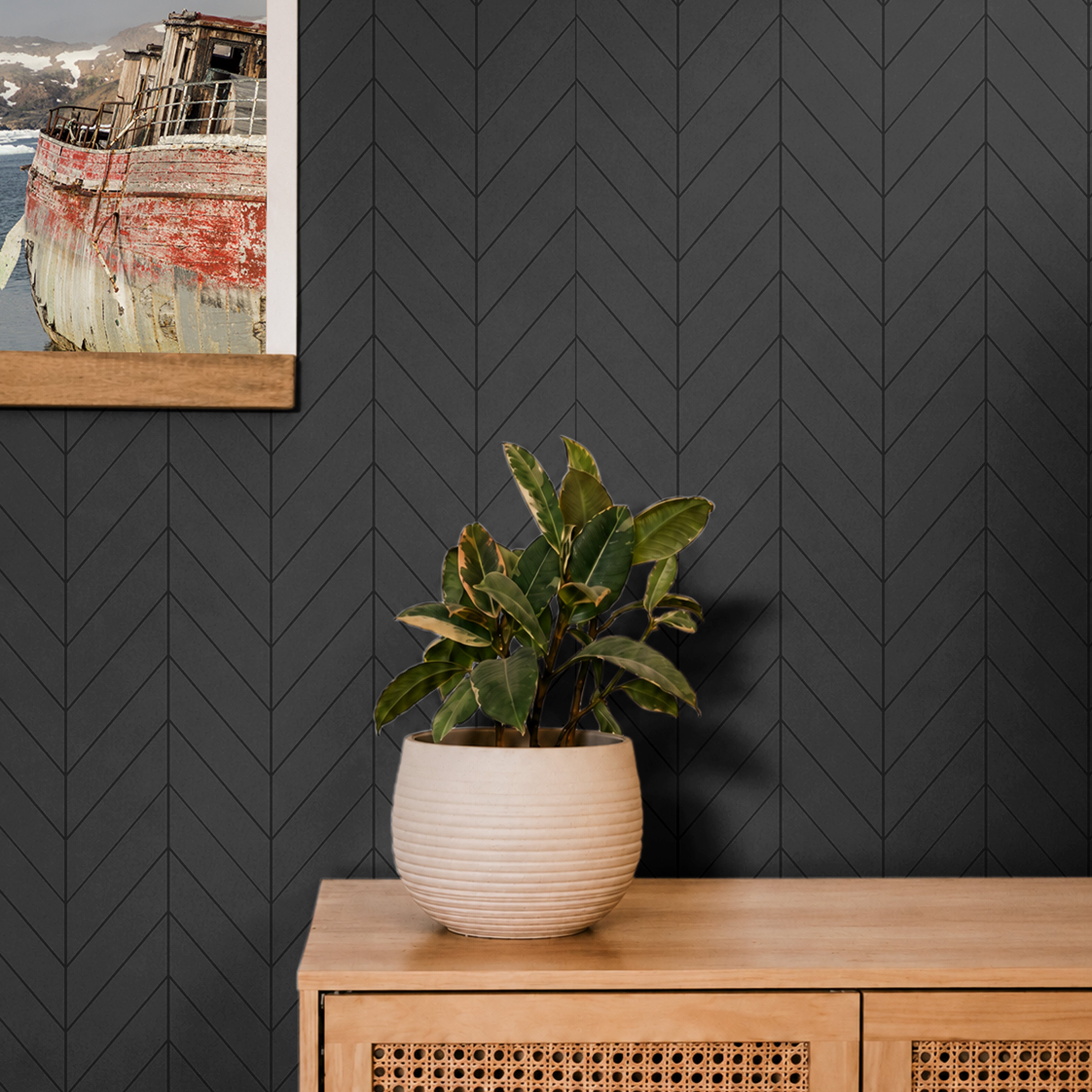 Black Geometrical Chevron pattern shiplap creating a dark and moody space in living area with boat pictures and plant life 
