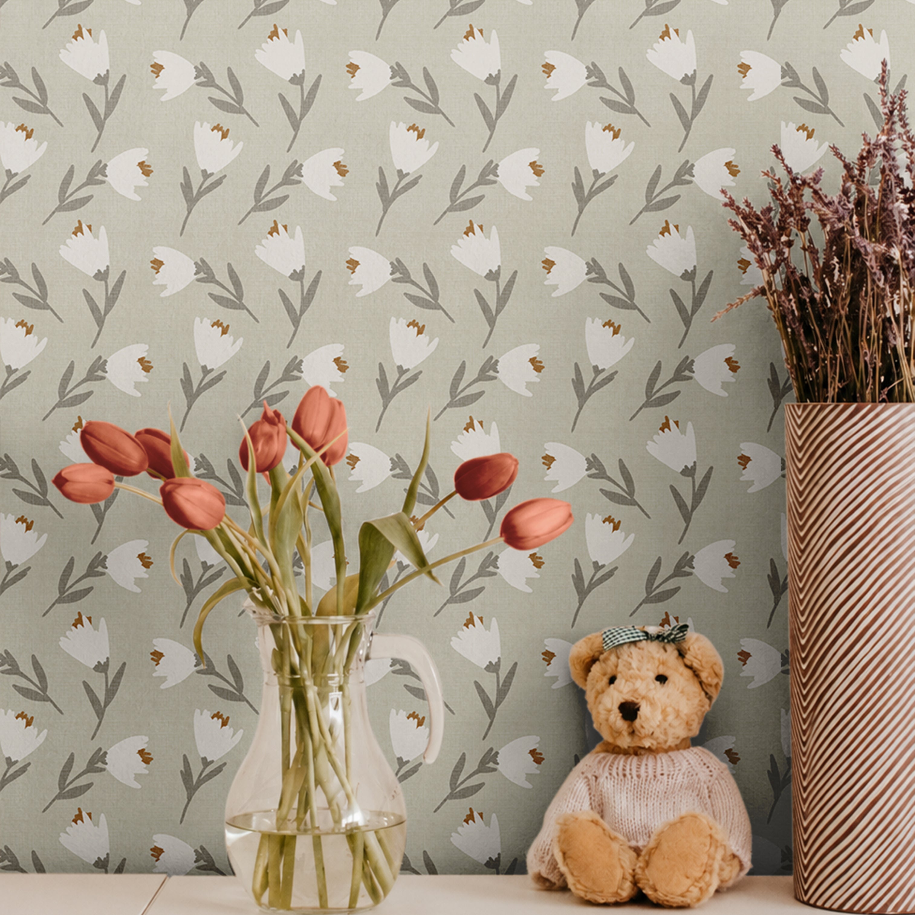 White and orange florals on light green sage background with linen like texture behind cube shelf with tulips and teddy bear