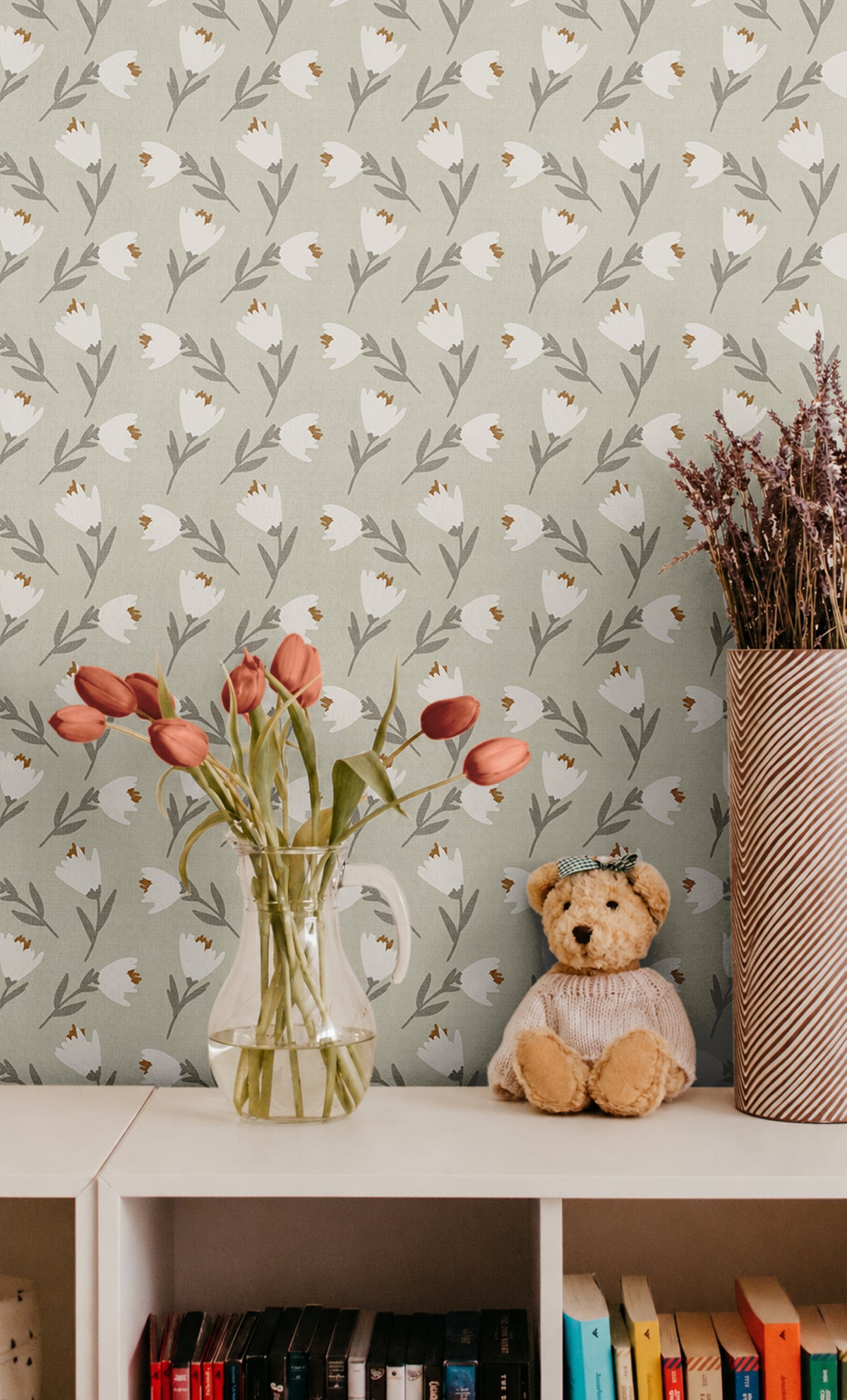 White and orange florals on light green sage background with linen like texture behind cube shelf with tulips and teddy bear