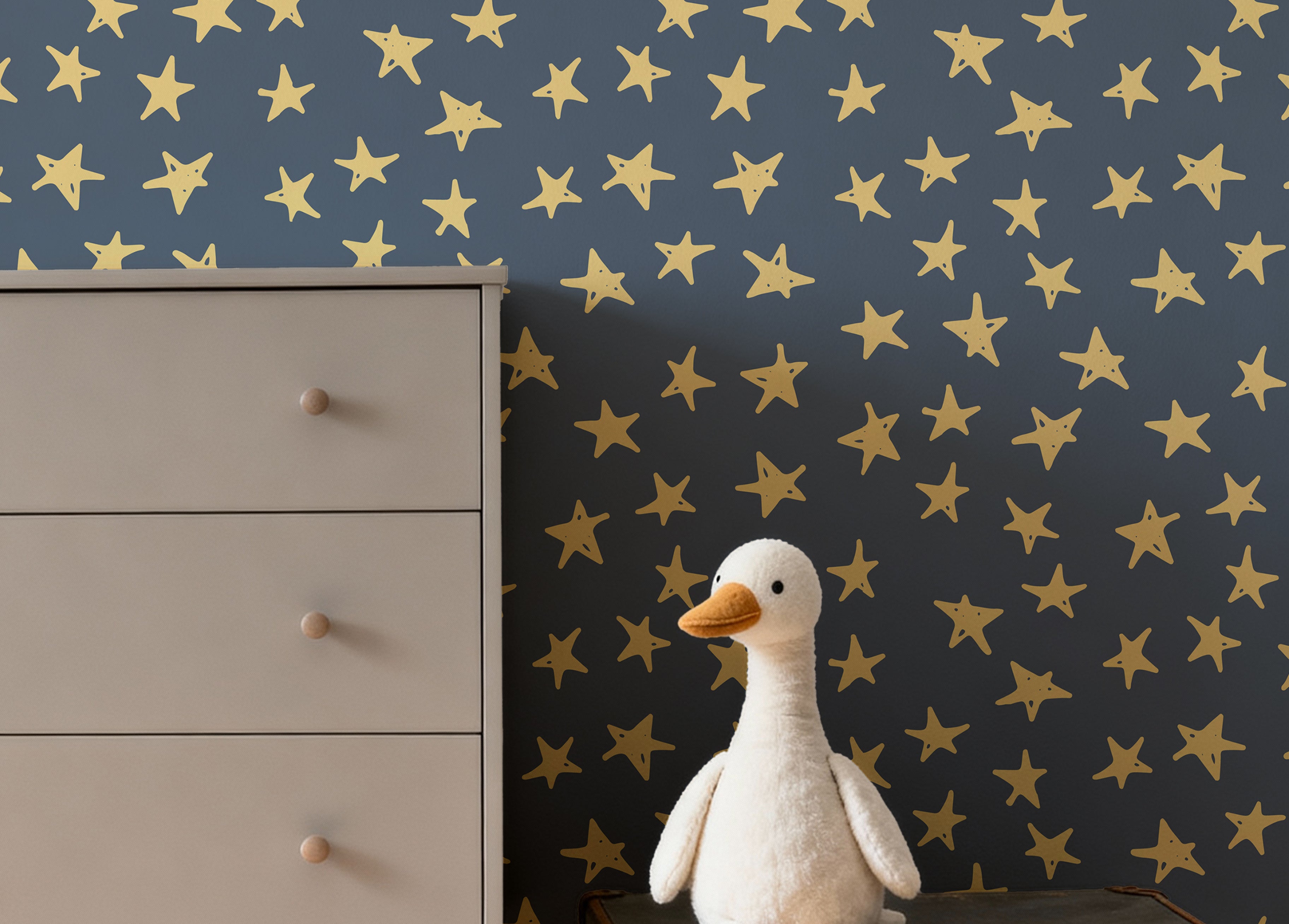 Deep blue background with yellow crayon drawn stars in kids room with dresser and a stuffed goose on top of a suitcase