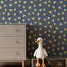 Deep blue background with yellow crayon drawn stars in kids room with dresser and a stuffed goose on top of a suitcase