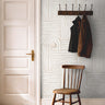 Cream and white art deco lined wallcovering in bright hallway with warm wooden accents