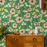 Blush pink florals on bright green background styled with warm wood tones and 