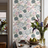 Green and pink toned roses with pops of orange in countertop dining space