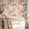 Muted pink floral wall covering styled with white nursery decor