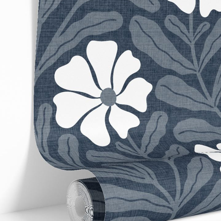 Luxury blue wallpaper roll with graphic white floral shapes and layered botanical background