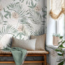 Oversized tropical palm leaves with white background styled in an airy reading nook