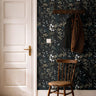Moody florals with white accents styled in bright hallway with warm wooden accents