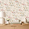 Delicate wildflower with daisies and poppies on light cream background in warm whimsical bedroom
