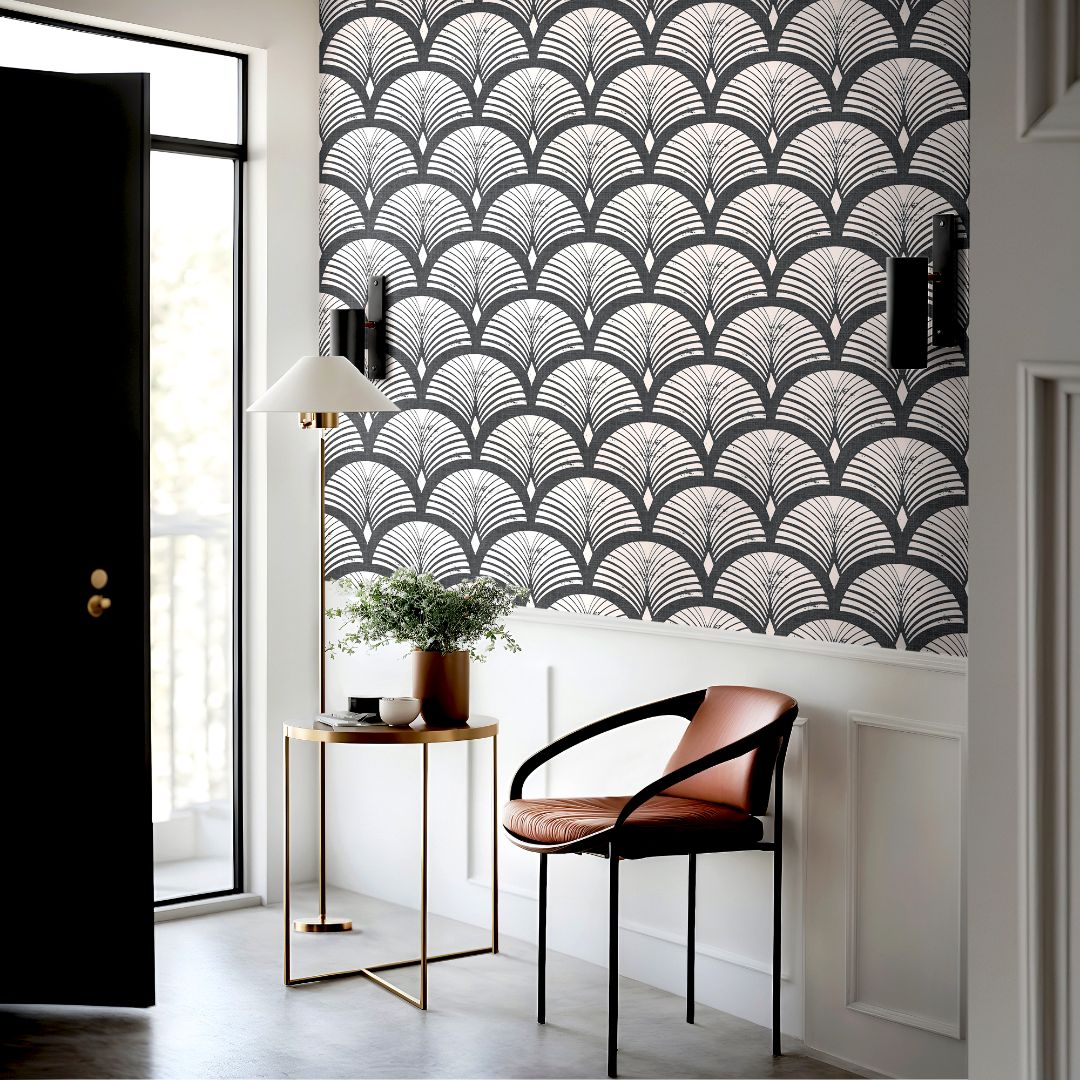 charcoal and blush art deco wallpaper above white paneling with black door brass table and rust chair