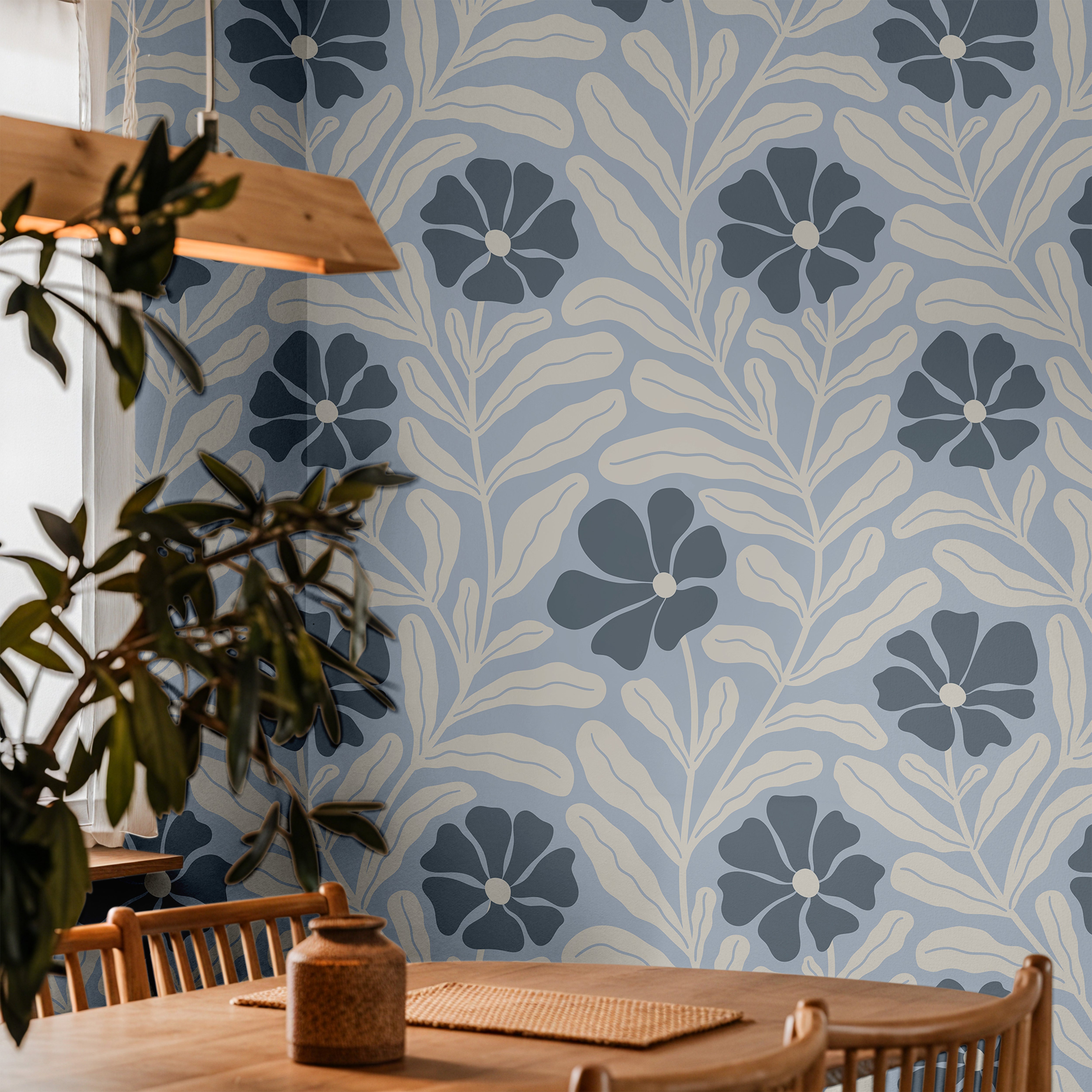 Baywell light blue floral wallpaper with navy flowers and cream botanical leaves styled in a warm dining room with wood furniture.
