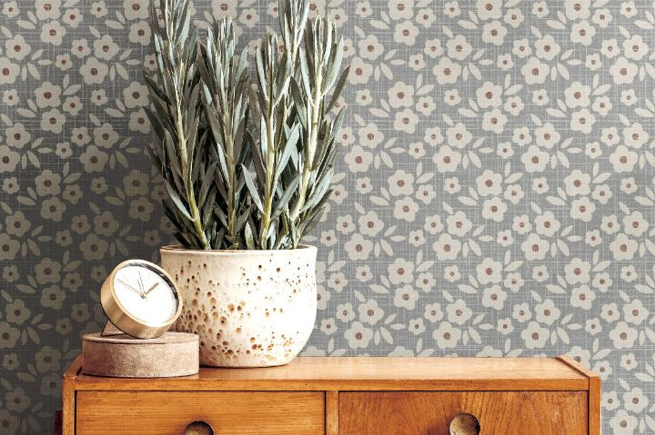 bluebell haven floral wallpaper styled behind mid century wood sideboard with potted plant