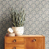 bluebell haven floral wallpaper styled behind mid century wood sideboard with potted plant