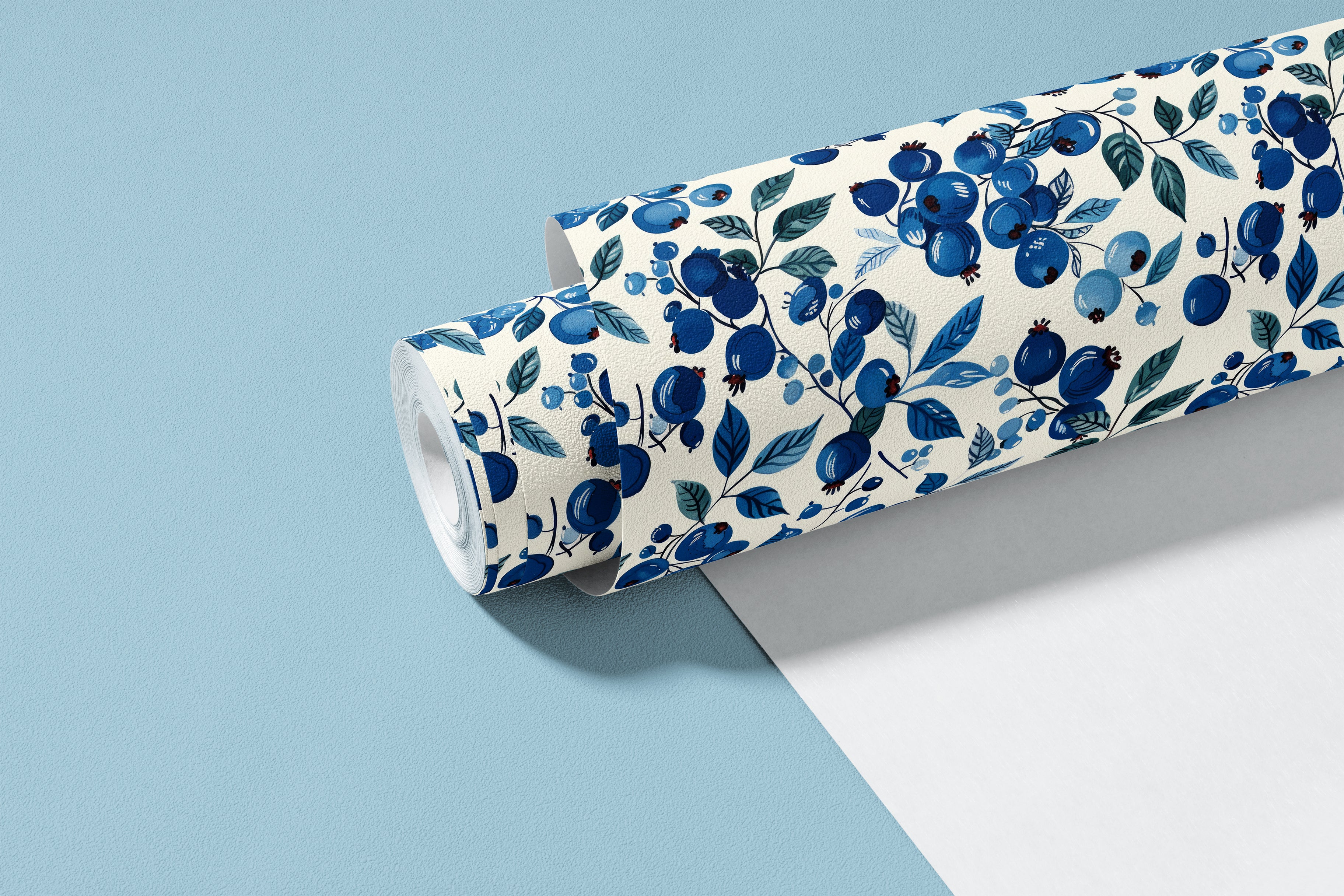 roll of blueberry branches contact paper with blue berries teal leaves and warm cream background on light blue backdrop