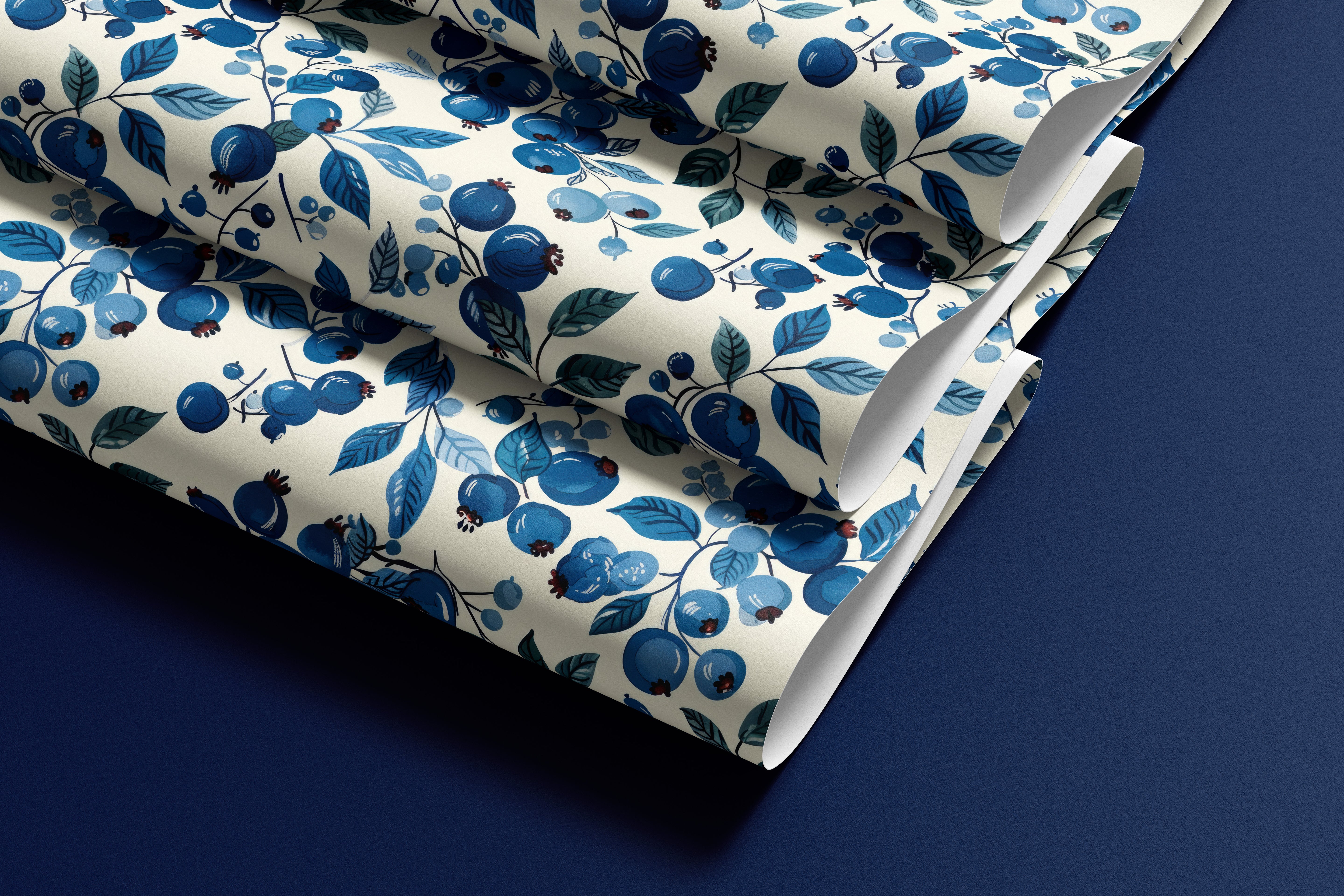 roll of blueberry branches contact paper with blue berries teal leaves and warm cream background on dark blue surface