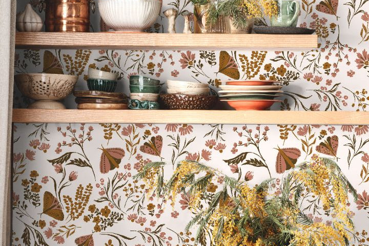 Close view of Brassmere Wilds botanical wallpaper pattern with brass toned florals, butterflies, and sage botanical stems.