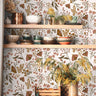 Close view of Brassmere Wilds botanical wallpaper pattern with brass toned florals, butterflies, and sage botanical stems.