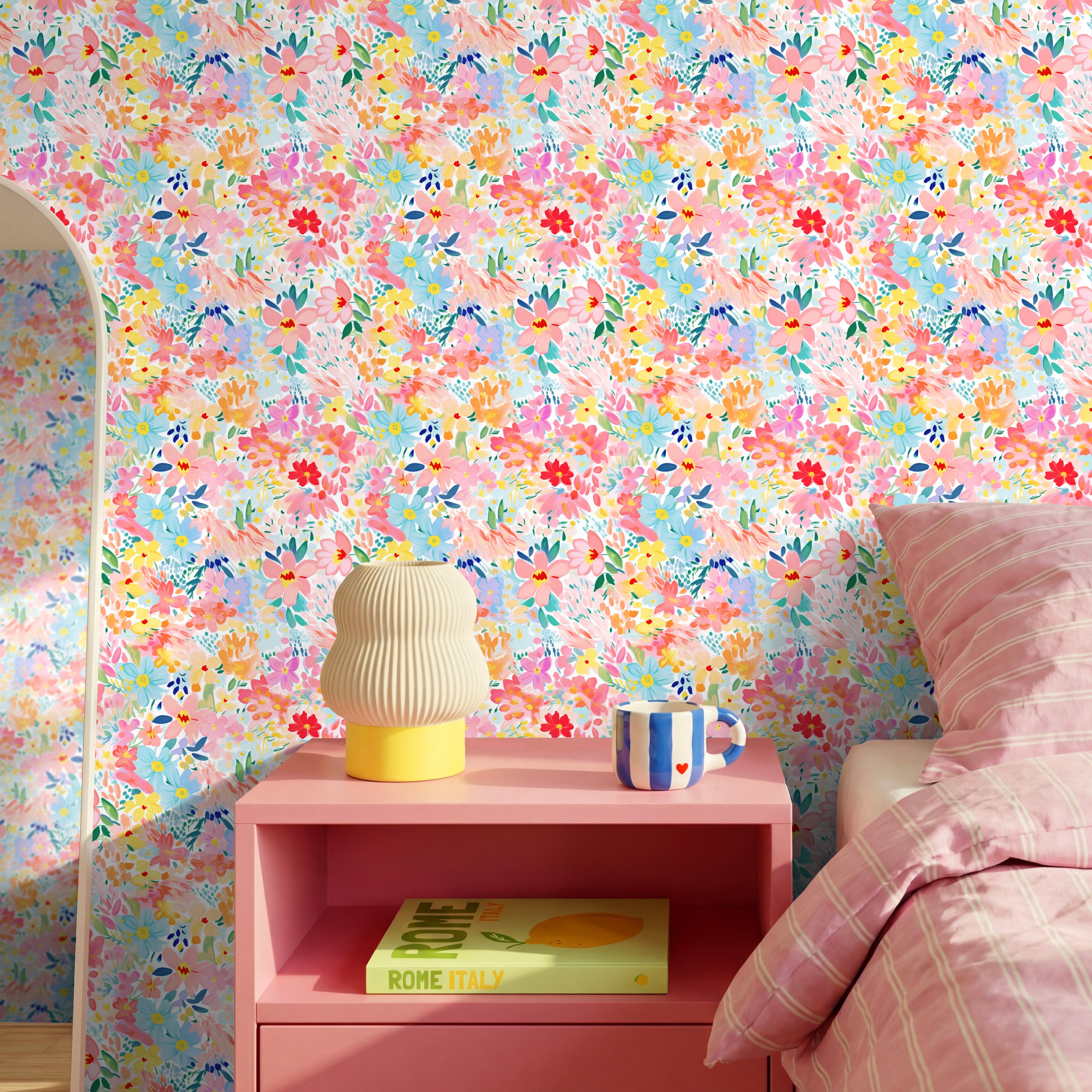 Colorful pastel floral wallpaper with painterly pink, peach, yellow, blue, and lavender flowers styled in a bright playful bedroom.
