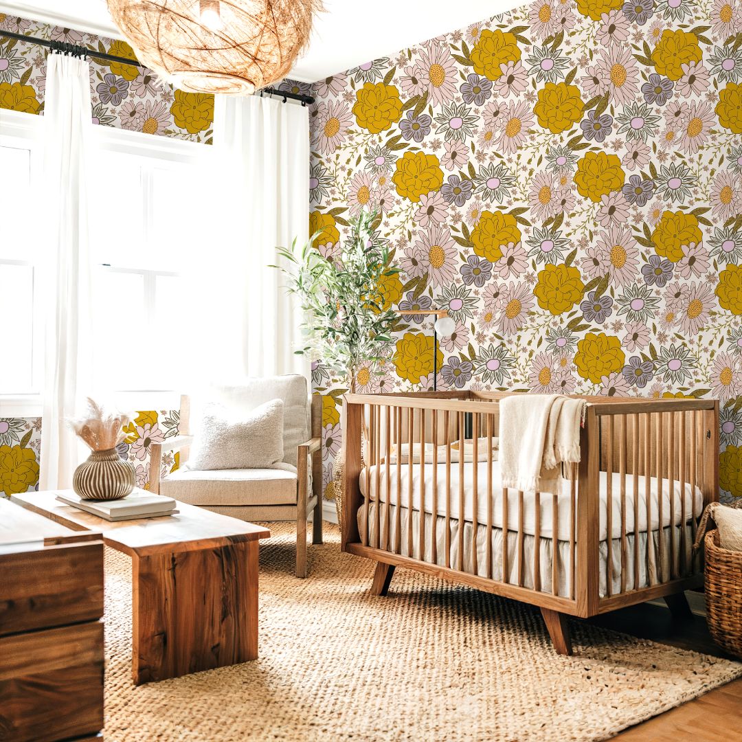 Butterbloom Field Wallpaper behind a nursery crib featuring golden flowers and pink daisies in a soft, sunlit room.