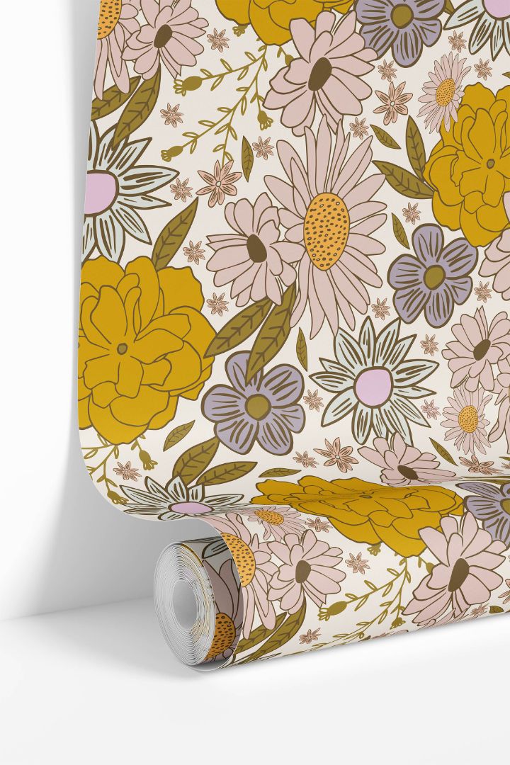 Roll of Butterbloom Field Wallpaper showing golden, blush, and cream floral pattern inspired by daisies and marigolds.