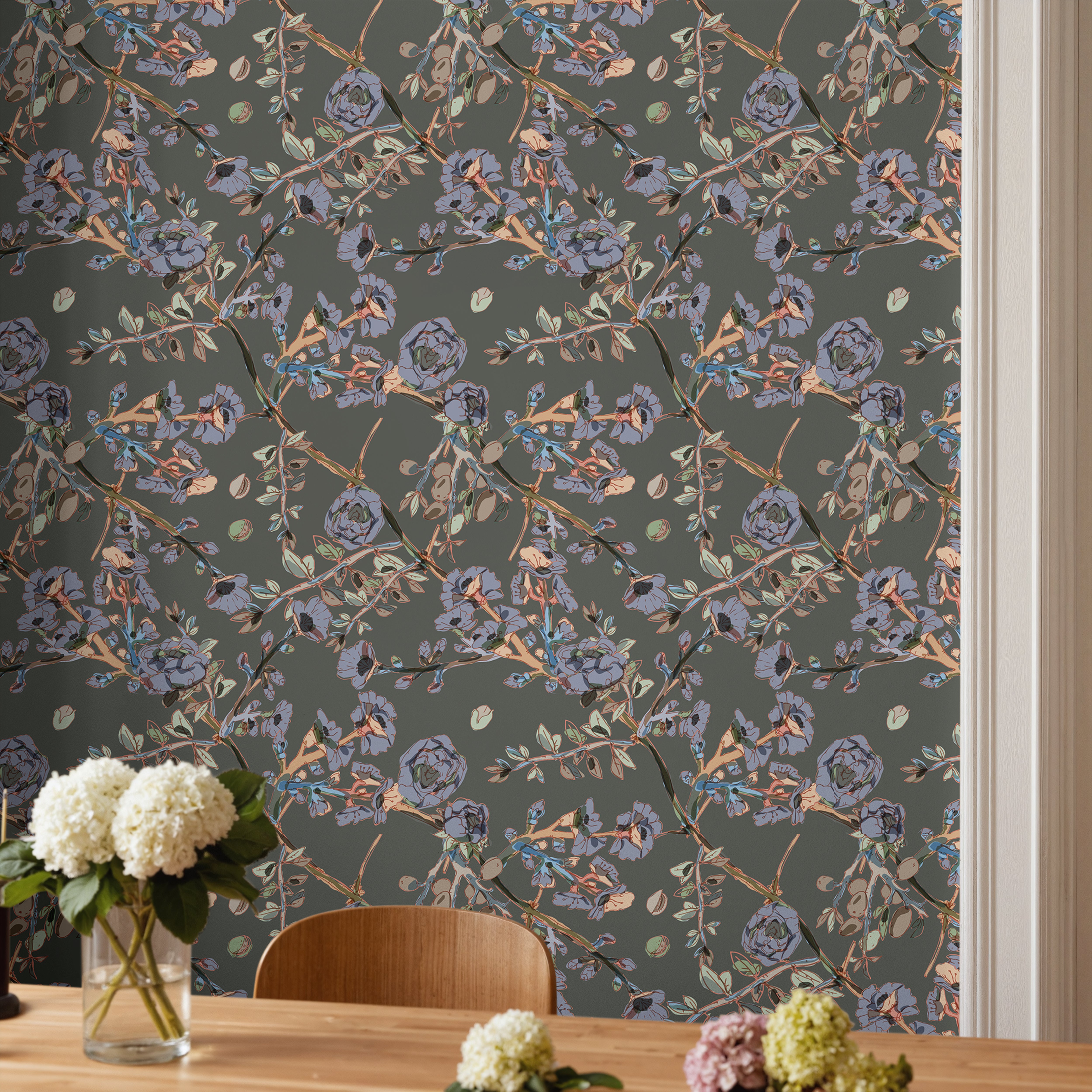 Dark floral wallpaper with painterly botanical branches in an elevated organic dining room interior.