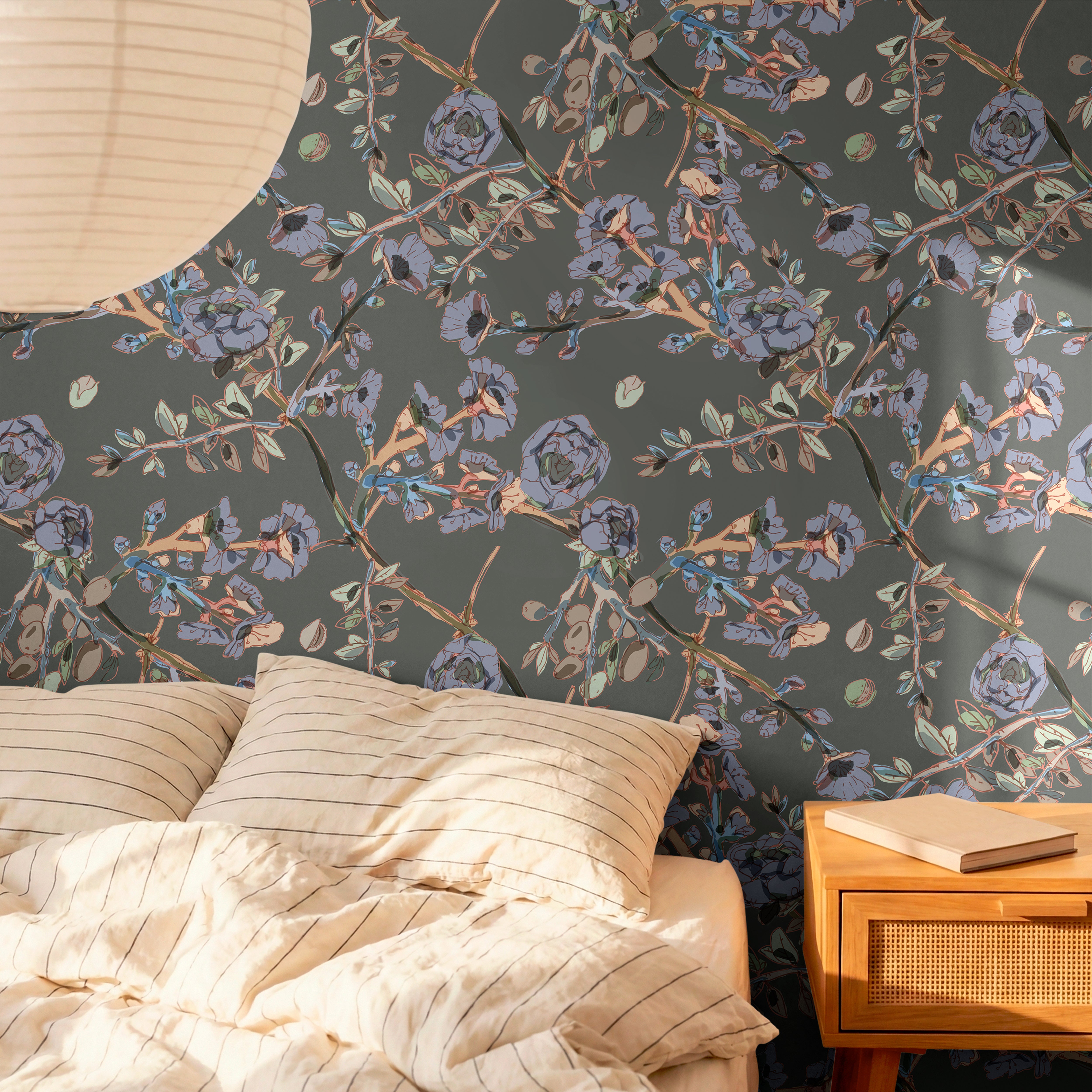 Moody botanical wallpaper with slate blue florals and olive branches in a warm modern bedroom interior.