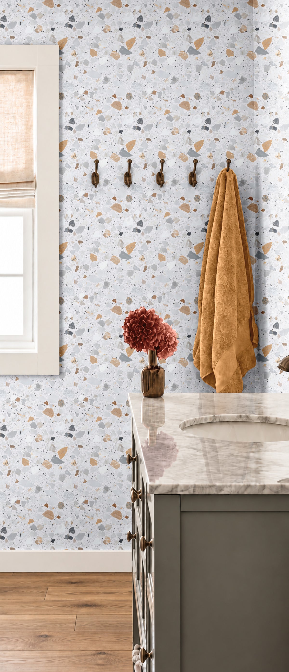 Cielo Terra 3144 terrazzo wallpaper with warm beige, gray and charcoal stone shapes on a soft white background styled in a modern bathroom