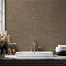 Neutral terrazzo wallpaper with clay and stone tones in a modern bathroom with brass fixtures