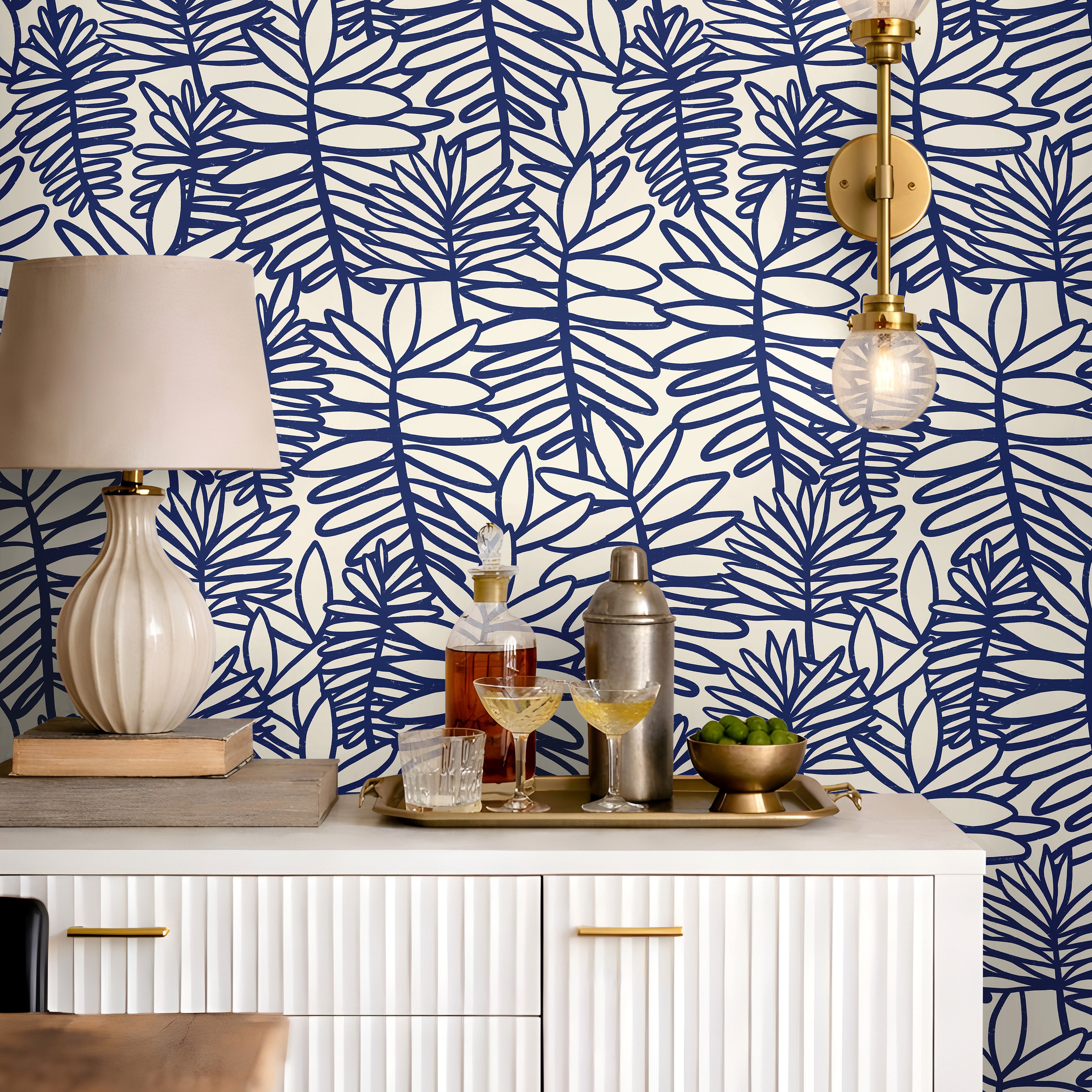 Modern coastal wallpaper featuring bold cobalt botanical leaves on a soft cream background