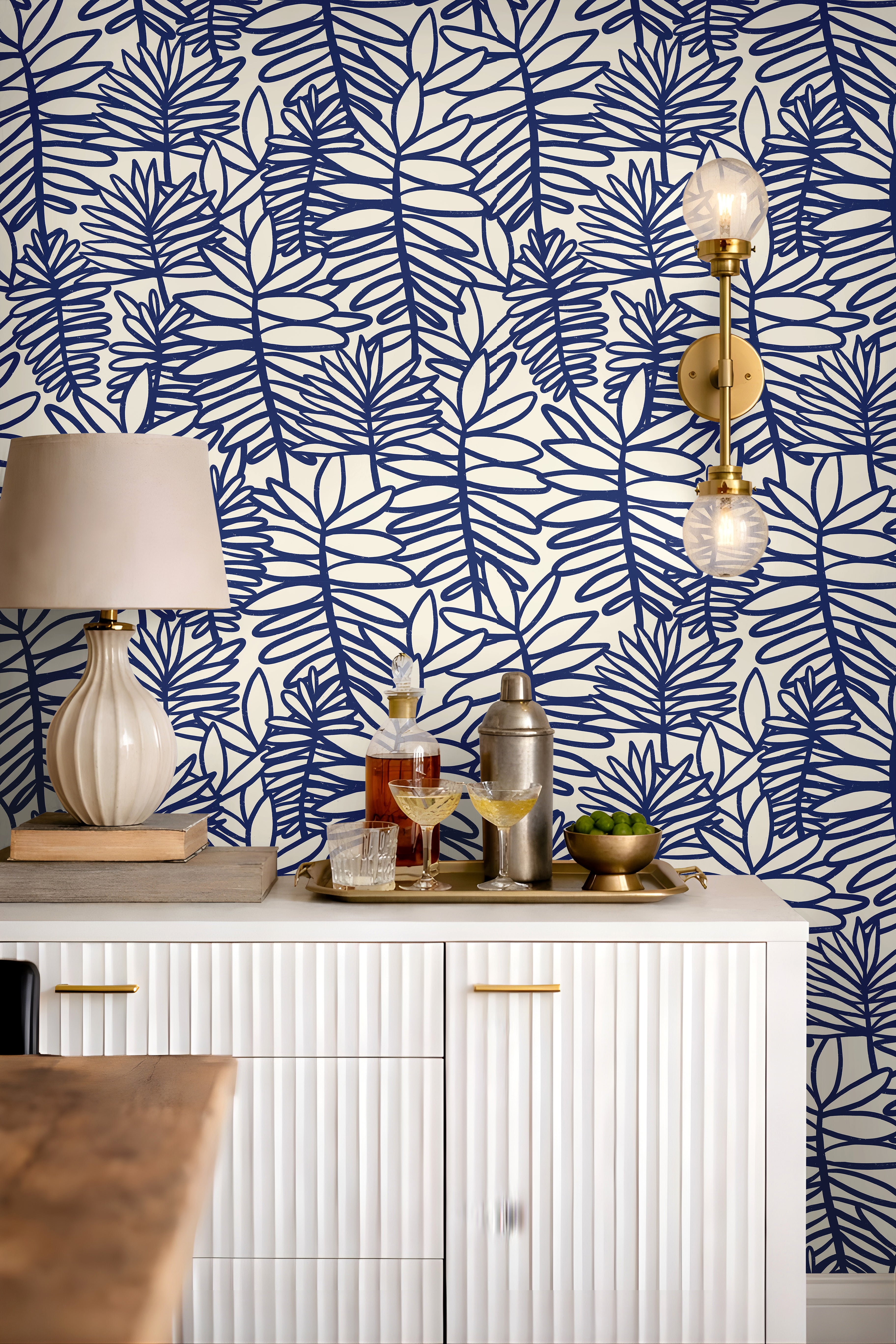 Modern coastal wallpaper featuring bold cobalt botanical leaves on a soft cream background