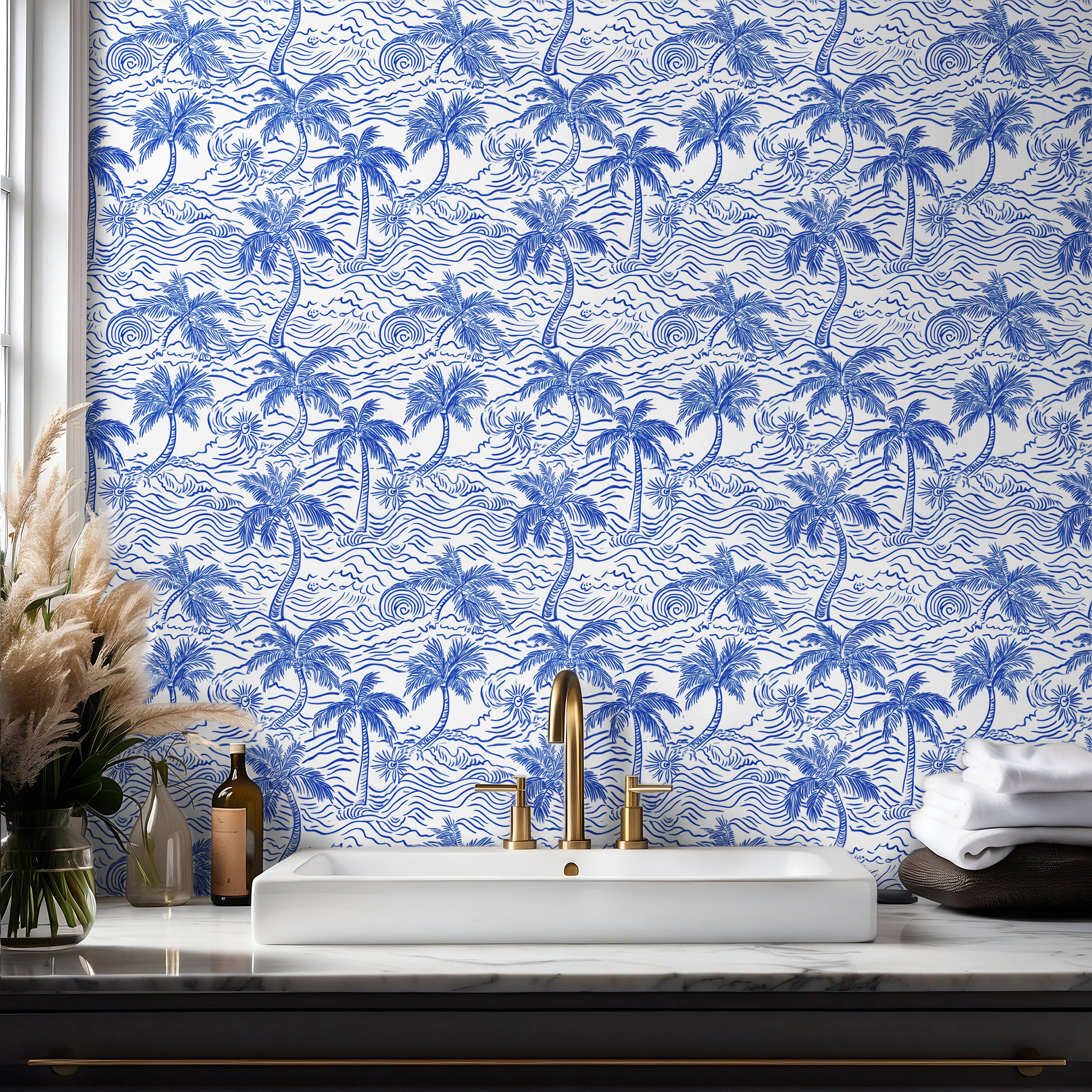 Tropical coastal wallpaper with hand drawn palm trees and ocean waves styled in bathroom with brass accented interior.