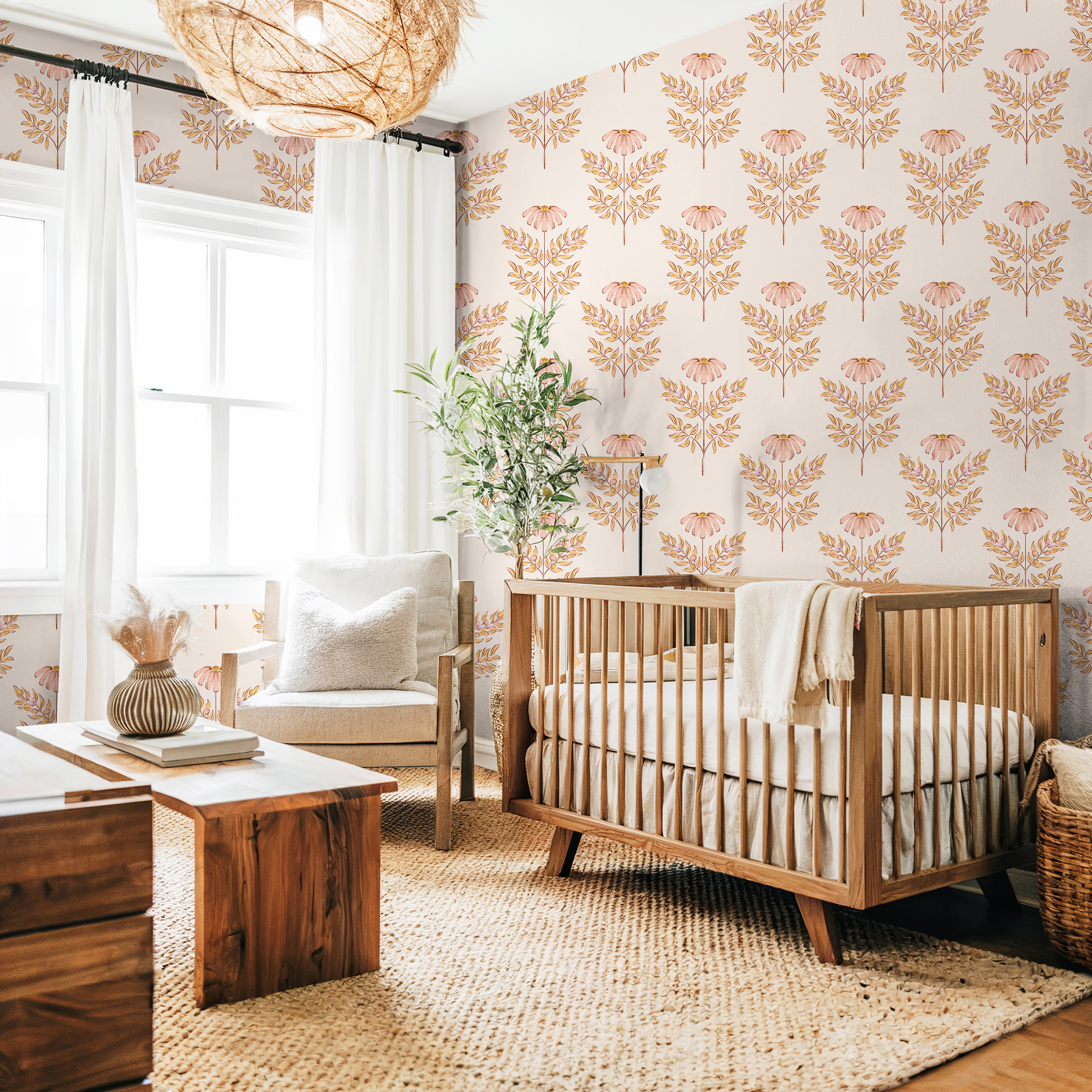 Blush botanical nursery wallpaper with watercolor coneflowers styled in a soft neutral nursery with woven textures and warm wood furniture.