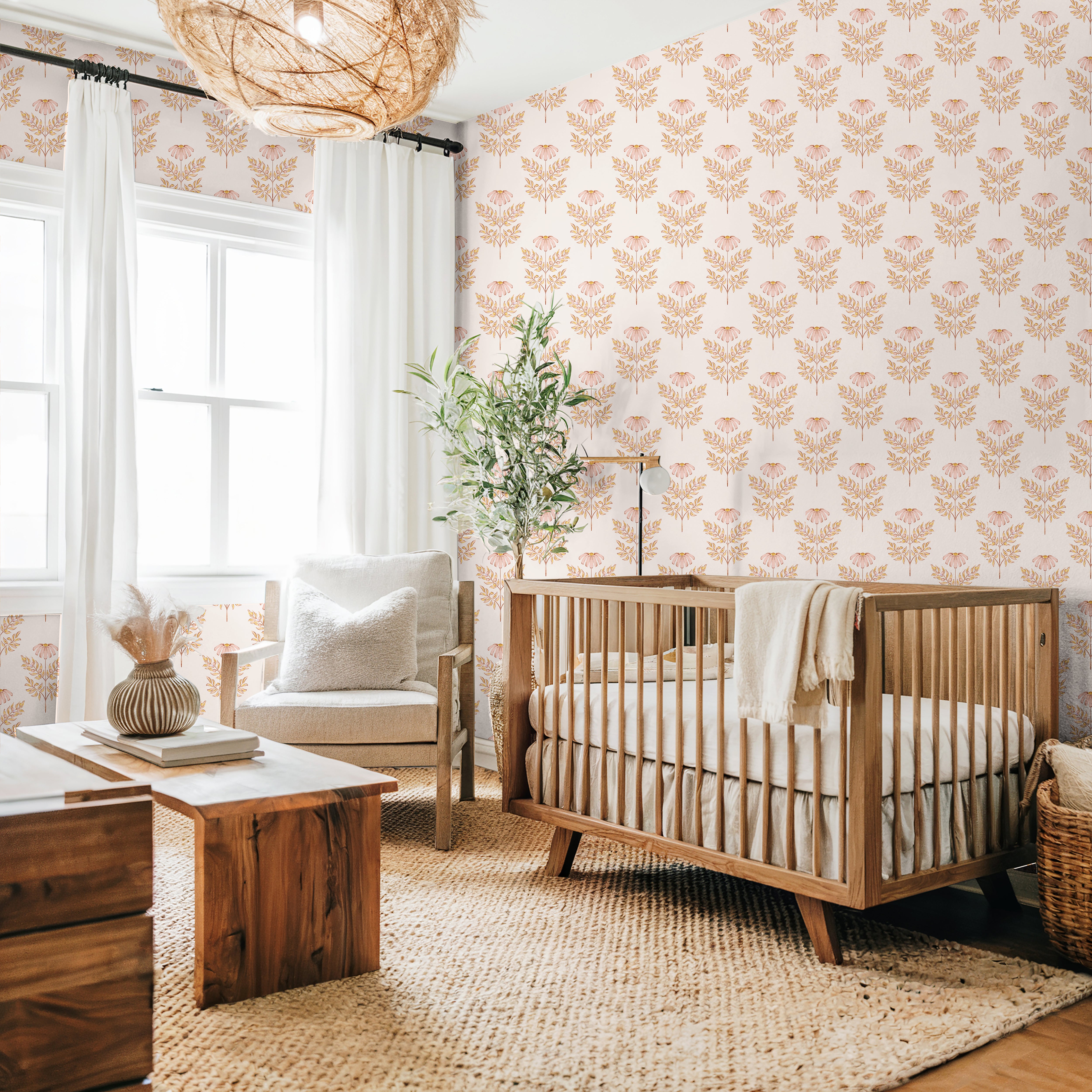 Blush botanical nursery wallpaper with watercolor coneflowers styled in a soft neutral nursery with woven textures and warm wood furniture.