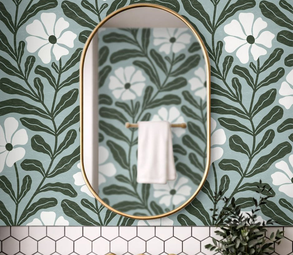 Close up of Driftwell floral wallpaper showing cool green botanical leaves and ivory flowers