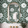 Close up of Driftwell floral wallpaper showing cool green botanical leaves and ivory flowers