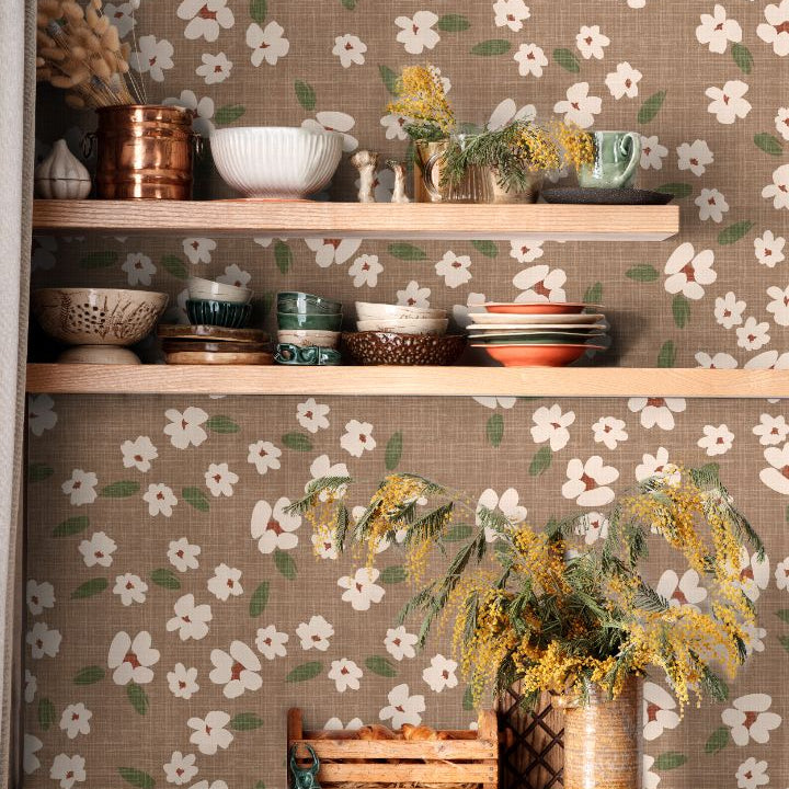 Floral wallpaper with ivory blooms and sage green leaves on a warm taupe background in a styled kitchen interior