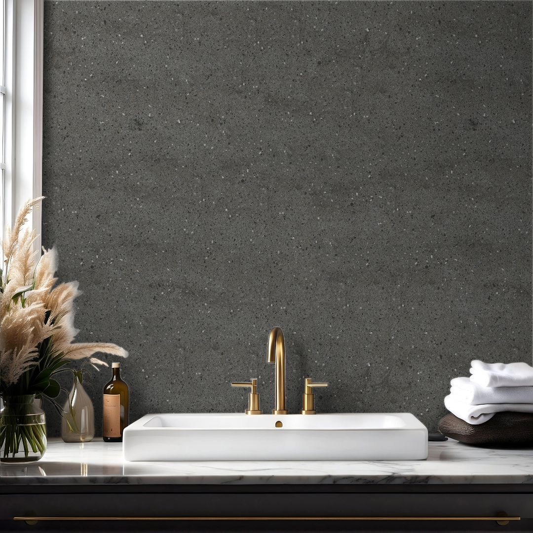 Dark graphite terrazzo wallpaper with subtle stone texture in a modern bathroom with brass fixtures