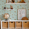 bee wallpaper with playful whimsical bees on teal wall in nursery storage space