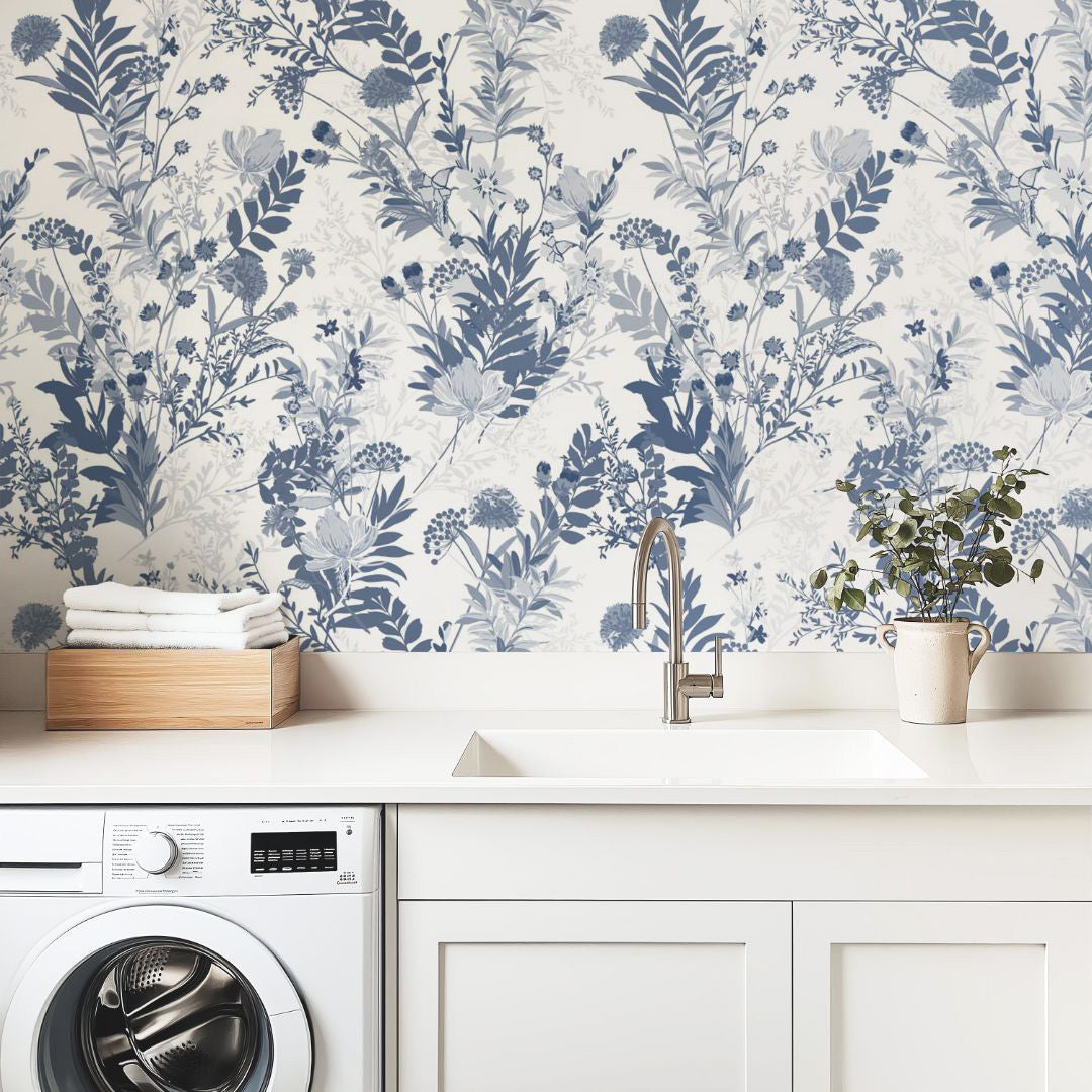 Indigo Meadow wallpaper behind bed with blue and white florals creating a calm, airy atmosphere